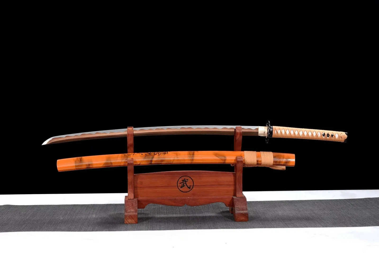 Katana Sabaku en acier au manganèse, lame marron, tsuba en fer, photo de couverture du guide « Mini katana : types, matières et idées pour exposer un sabre réduit »
