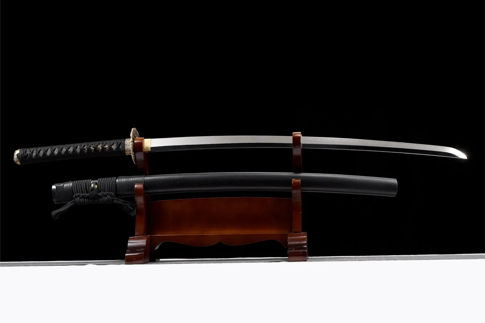 Katana Shishi en acier T10 à hamon, poli miroir et saya noire sobre, photo de couverture du guide « Samouraï : qui étaient-ils vraiment, des origines à Meiji »